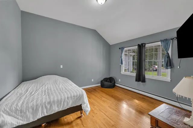 a bedroom with a bed and a flat tv screen