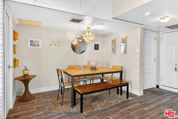a view of a livingroom and a dining room with furniture wooden floor and a chandelier
