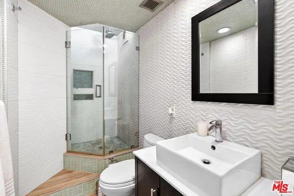 a bathroom with a sink toilet and shower