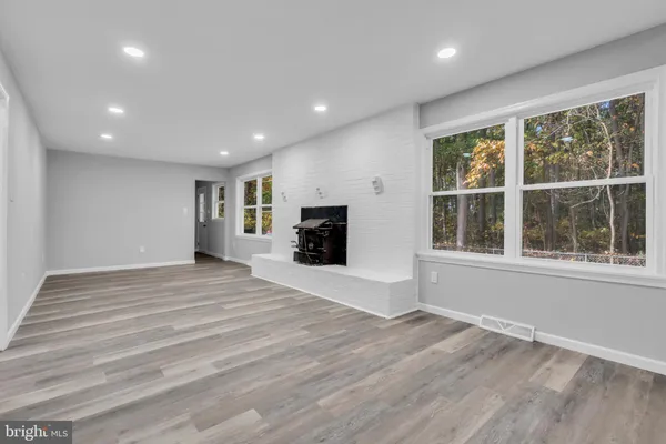 a view of empty room with wooden floor and fireplace