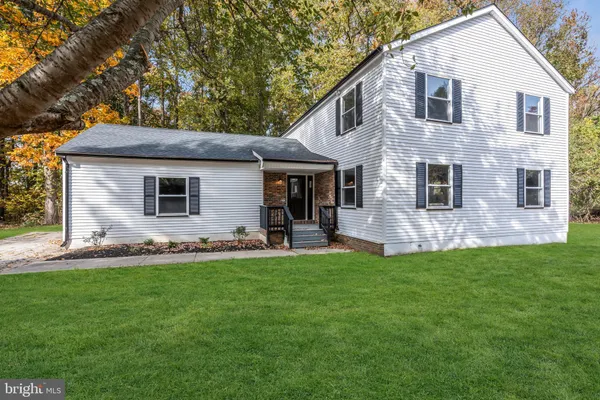 a view of a house with a yard and sitting area
