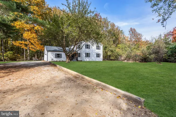 a front view of a house with a yard and trees
