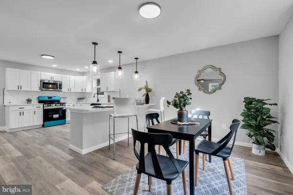 a kitchen with white cabinets and dining table chair