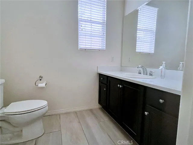 a bathroom with a sink a toilet and a window