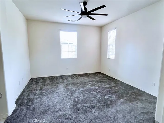 a view of a room with a ceiling fan and window
