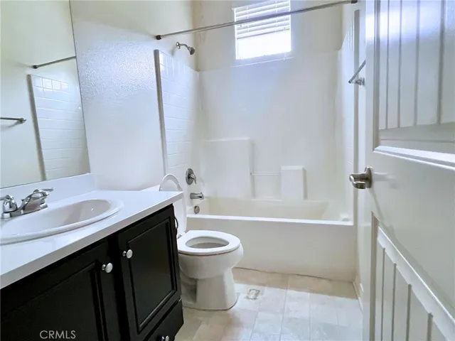 a bathroom with a tub sink toilet and a mirror