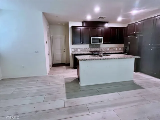 a kitchen with stainless steel appliances granite countertop a sink stove and refrigerator