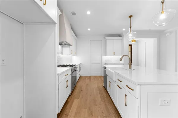 a kitchen with white cabinets sink and stainless steel appliances