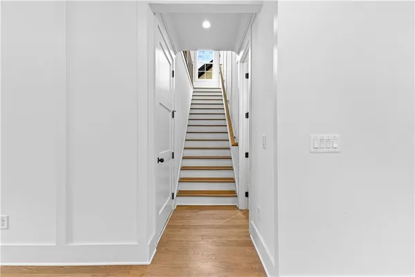 a view of a hallway with wooden floor and stairs