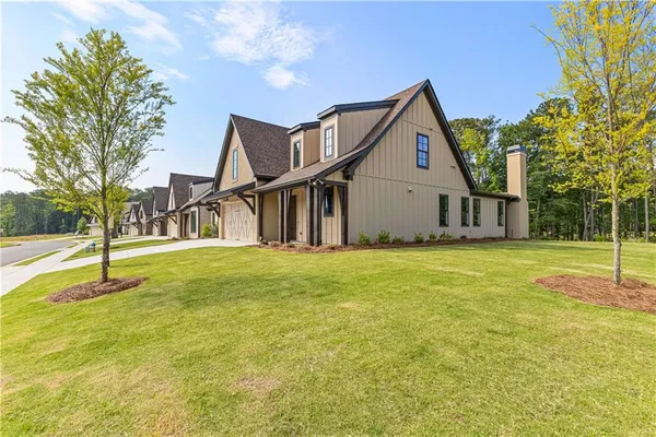 a view of a house with a backyard and a tree