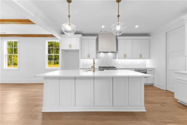 a kitchen with kitchen island granite countertop a sink cabinets and window