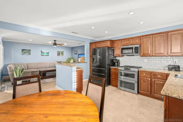 a kitchen with stainless steel appliances kitchen island granite countertop a refrigerator a stove top oven and a sink