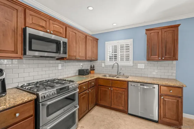 a kitchen with sink a microwave and cabinets