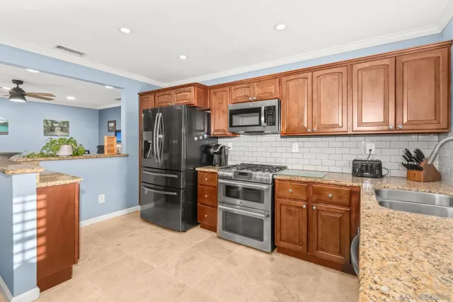 a kitchen with stainless steel appliances granite countertop a refrigerator stove and sink