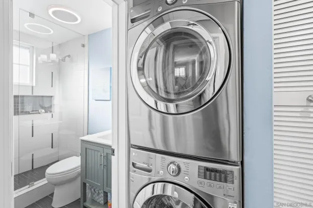 a view of a bathroom with washing machine and racks