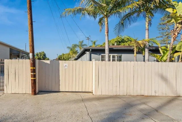 a view of a house with a small yard and a large tree