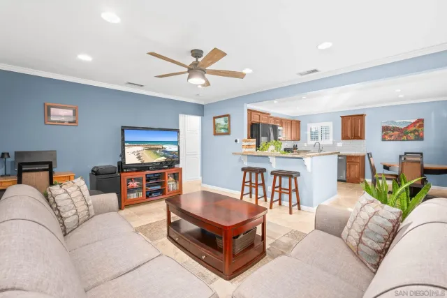 a living room with furniture kitchen view and a window