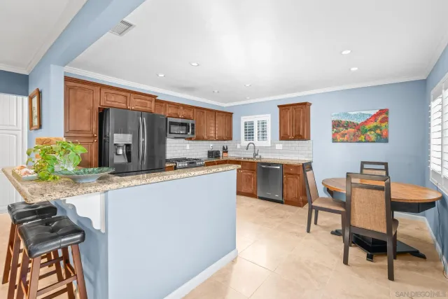 a kitchen with stainless steel appliances granite countertop a stove a sink a refrigerator and a refrigerator