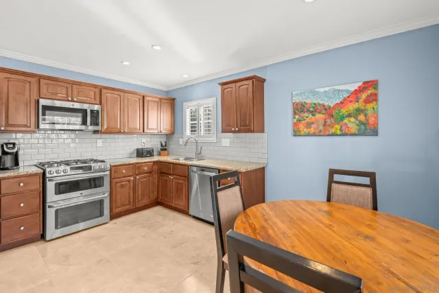 a kitchen with stainless steel appliances granite countertop a stove top oven a sink dishwasher and a microwave oven on the blue kitchen countertops