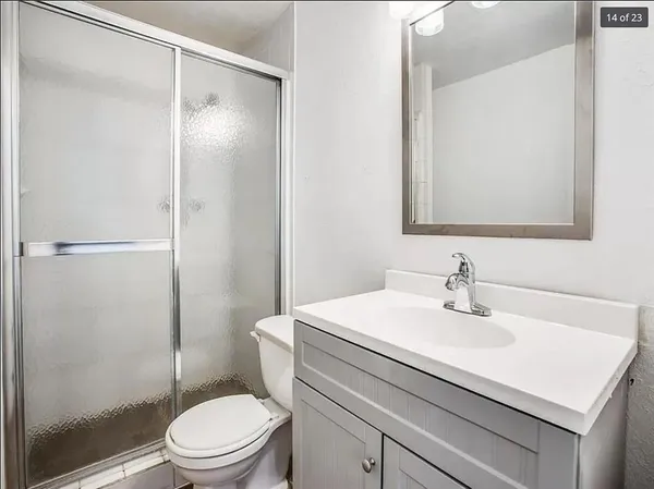 a bathroom with a sink toilet vanity and shower