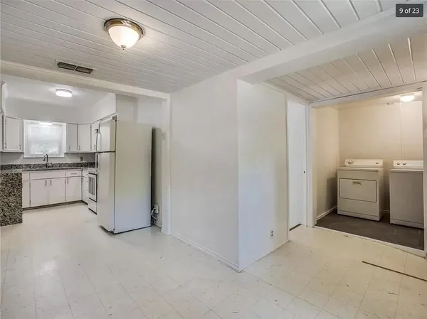 a view of a kitchen with refrigerator and white cabinets