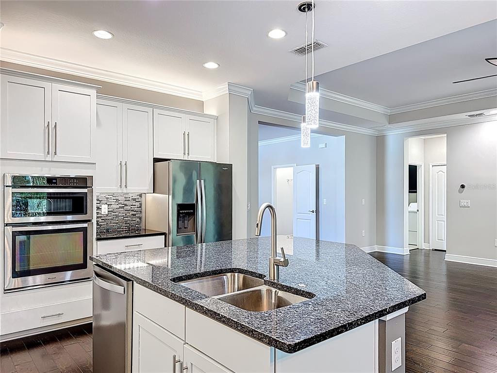 2894 Sand Oak Loop Apopka, FL 32712 - Photo 3 of 69 a kitchen with stainless steel appliances granite countertop a sink refrigerator and microwave