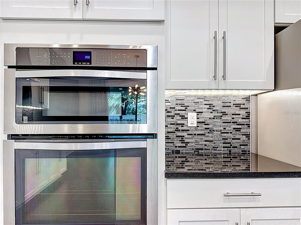 2894 Sand Oak Loop Apopka, FL 32712 - Photo 55 of 69 a kitchen with granite countertop a stove and a microwave