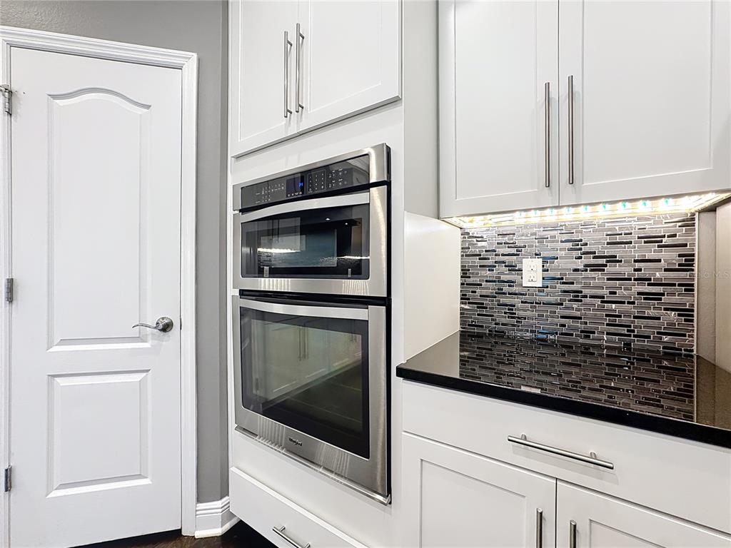 2894 Sand Oak Loop Apopka, FL 32712 - Photo 56 of 69 a kitchen with granite countertop white cabinets and stainless steel appliances
