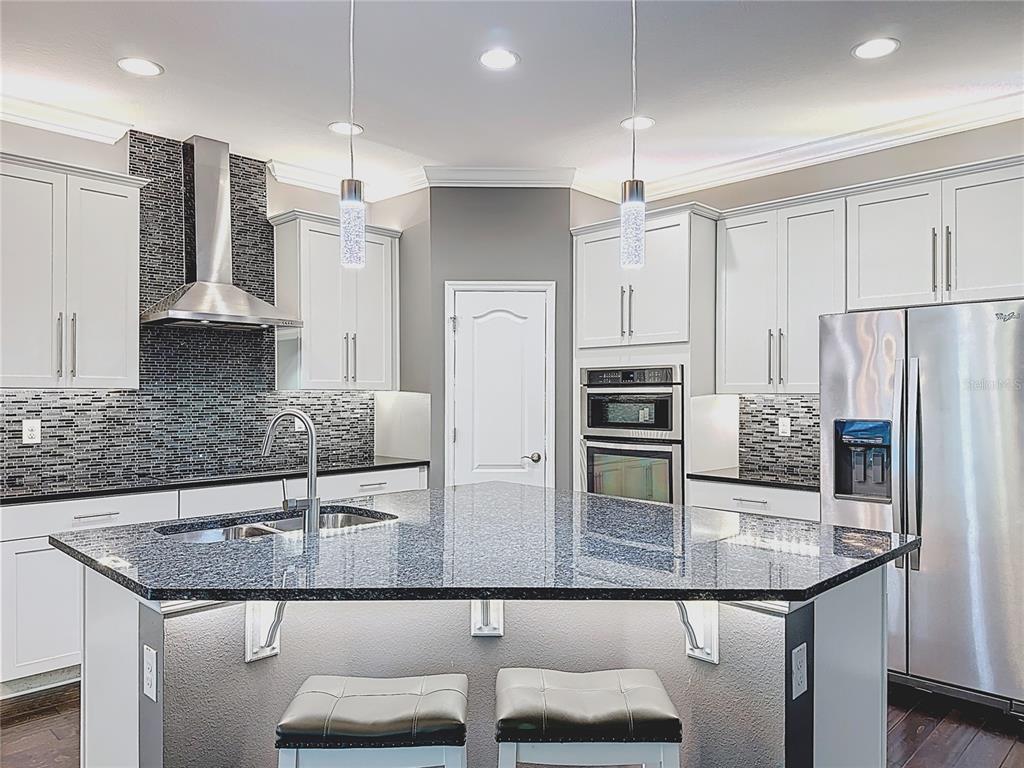 2894 Sand Oak Loop Apopka, FL 32712 - Photo 7 of 69 a kitchen with stainless steel appliances granite countertop a sink and a refrigerator
