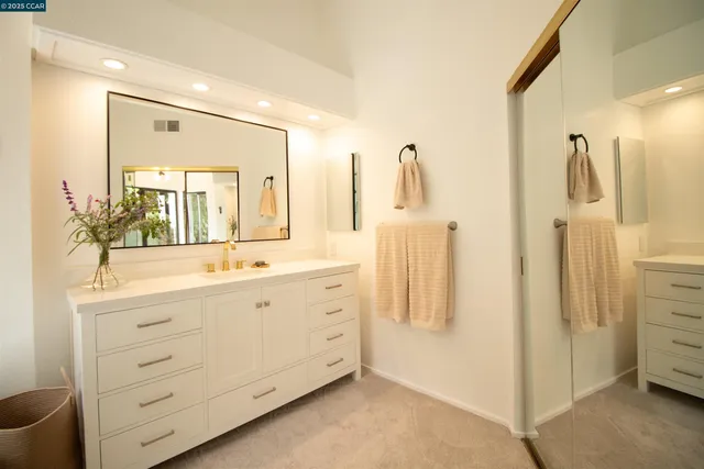 a spacious bathroom with a double vanity sink a mirror and a shower