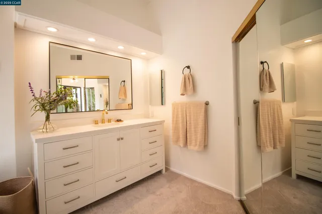 a kitchen with stainless steel appliances a stove a sink a refrigerator dining table and chairs