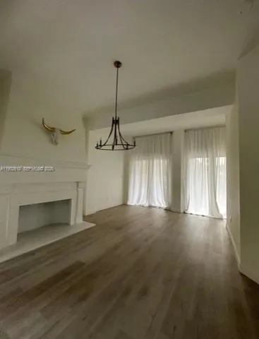 a view of an empty room with a fireplace and a window