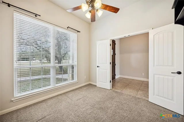 a view of livingroom with window ceiling fan and front door