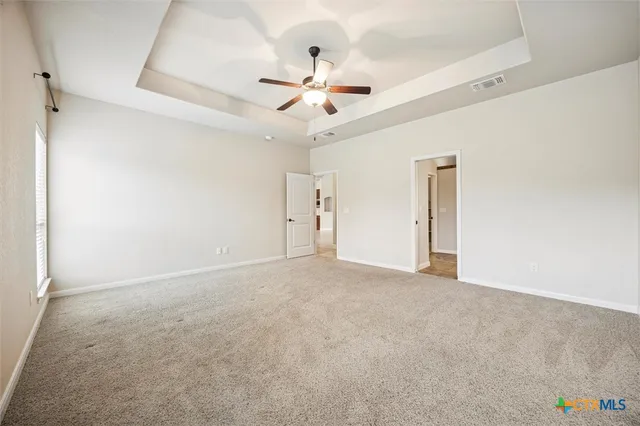 an empty room with fan and windows