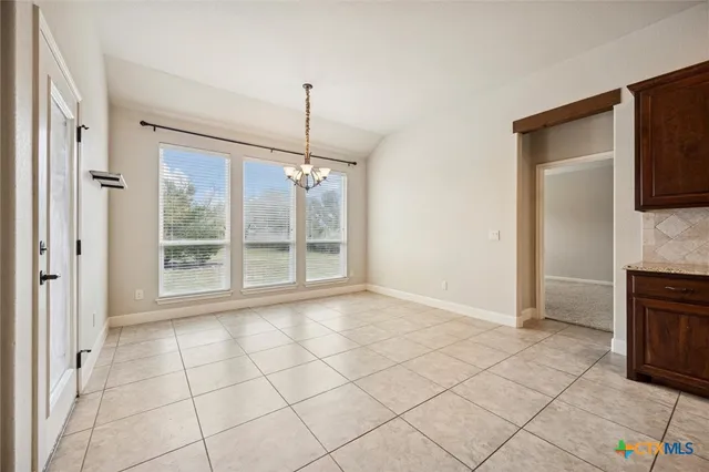 a view of an empty room with a fireplace and a window