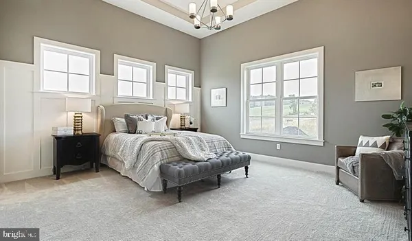 a spacious bedroom with a bed and a chandelier