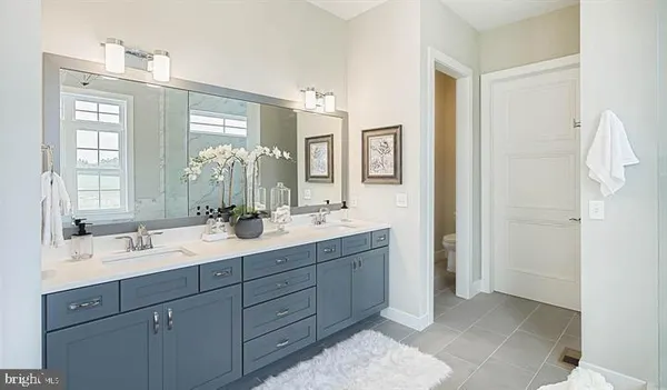 a bathroom with a double vanity sink mirror and next to a window