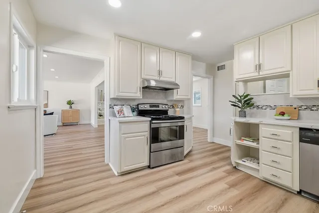 a kitchen with granite countertop white cabinets and white appliances