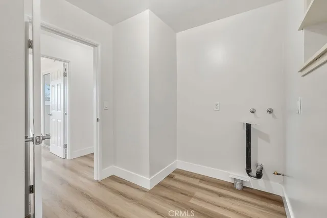 an empty room with wooden floor and mirror