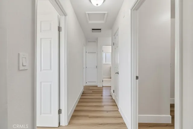a view of a hallway with wooden floor and staircase