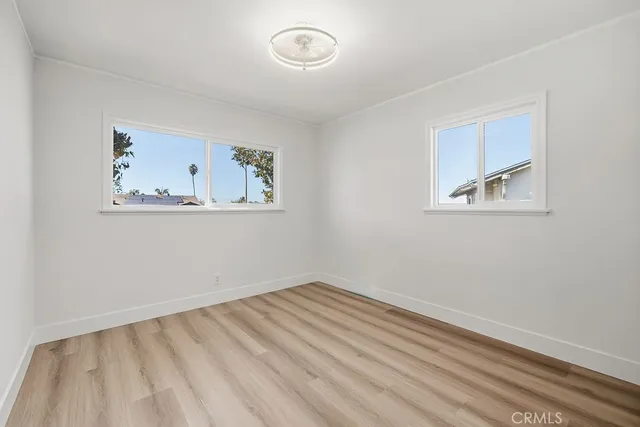 an empty room with a window and a painting on the wall