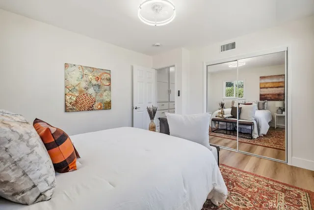 a bedroom with a bed and wooden floor