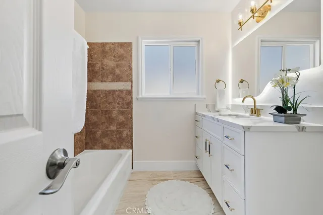 a bathroom with a tub sink and mirror