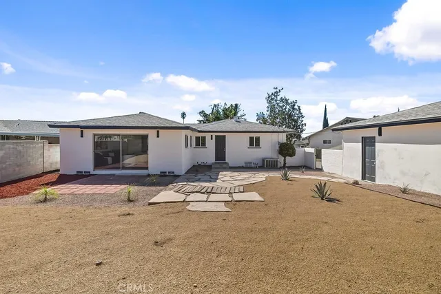 a backyard of a house with table and chairs