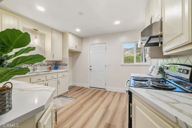 a kitchen with kitchen island granite countertop a stove and a sink