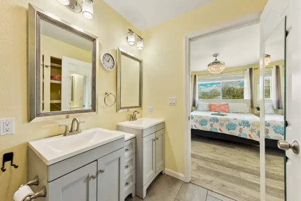 a en suite bathroom with sink double vanity and mirror