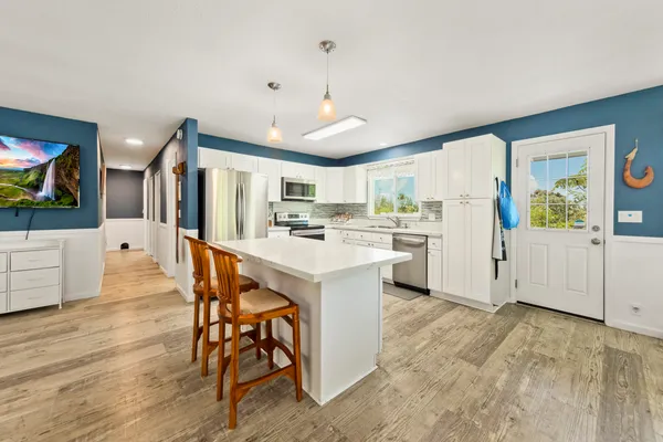 a kitchen with a table chairs refrigerator and microwave