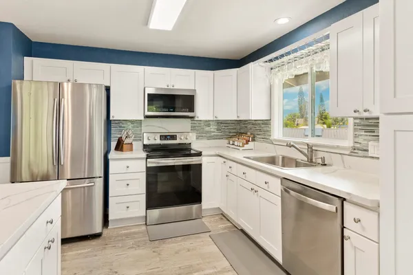a kitchen with white cabinets and stainless steel appliances