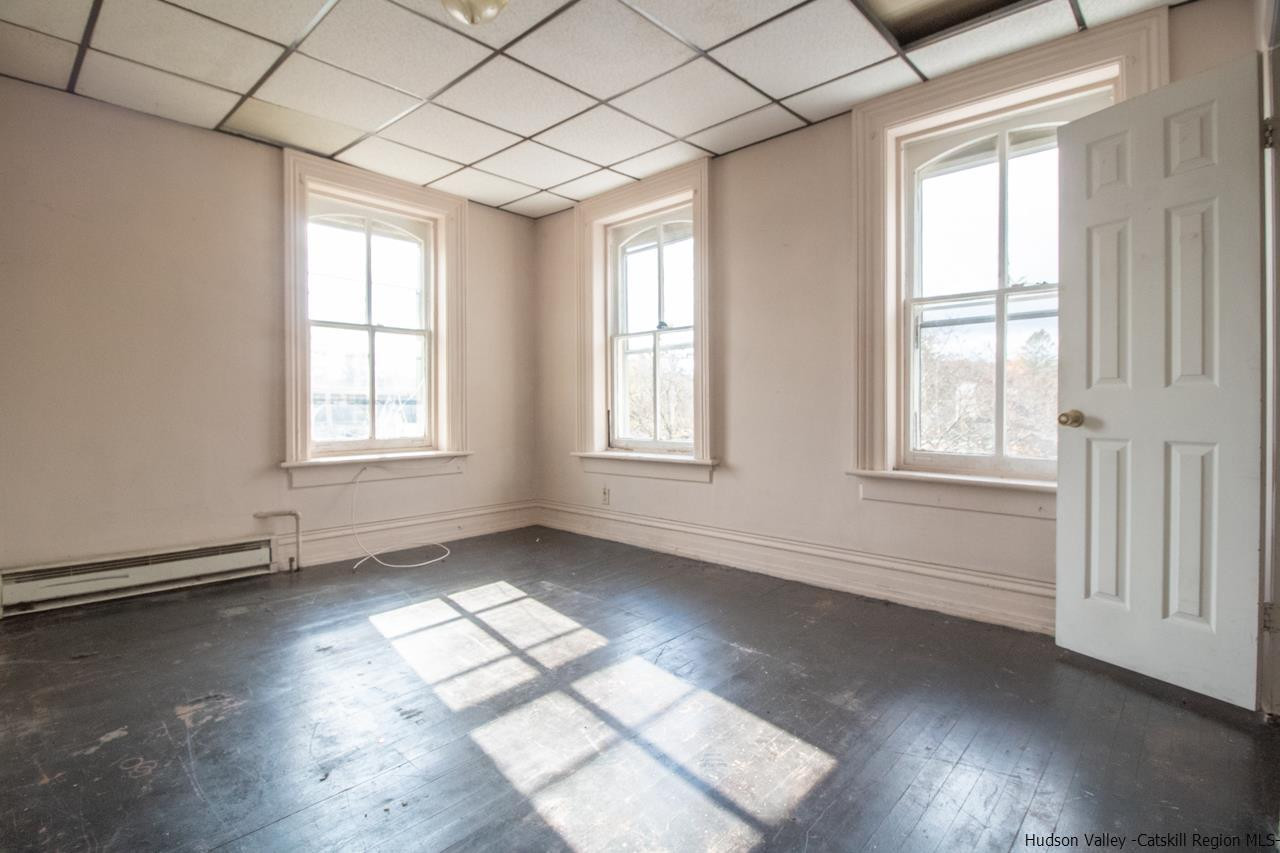 Undisclosed Address Kingston, NY 12401 - Photo 27 of 33 an empty room with wooden floor and windows with curtains