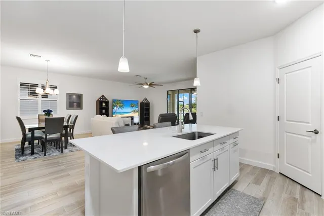 a kitchen with a sink a counter space and wooden floor